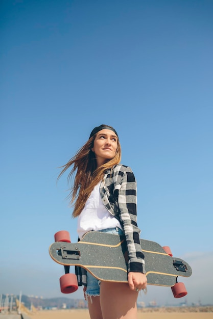 Portret młodej kobiety z longboardem