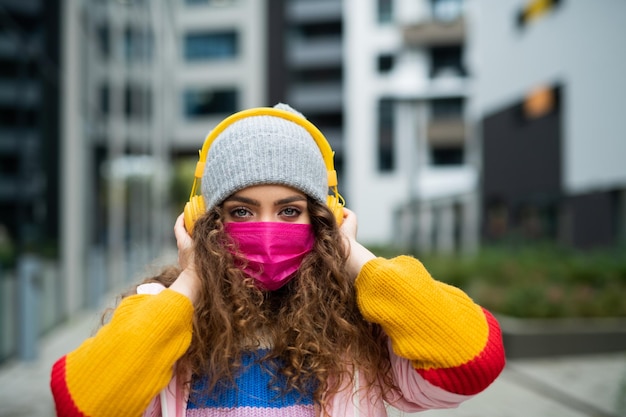 Zdjęcie portret młodej kobiety z maską na zewnątrz na ulicy, koncepcja koronawirusa.