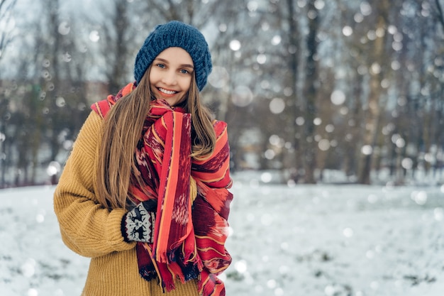 Portret młodej kobiety zima. Piękna radosna modelka Dziewczyna śmieje się i świetnie się bawi w winter park. Piękna młoda kobieta na zewnątrz, cieszyć się przyrodą, zima