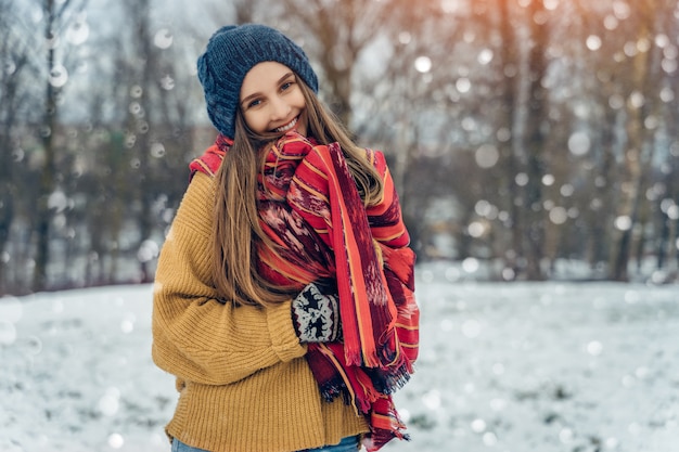 Portret młodej kobiety zima. Piękna radosna modelka Dziewczyna śmieje się i świetnie się bawi w winter park. Piękna młoda kobieta na zewnątrz, cieszyć się przyrodą, zima