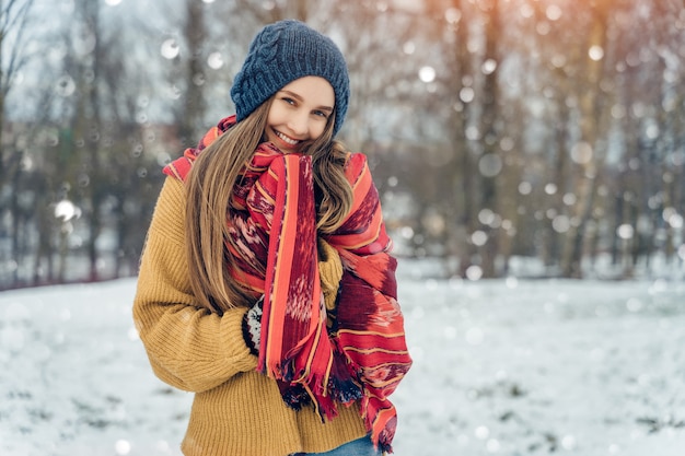 Portret młodej kobiety zima. Piękna radosna modelka Dziewczyna śmieje się i świetnie się bawi w winter park. Piękna młoda kobieta na zewnątrz, cieszyć się przyrodą, zima