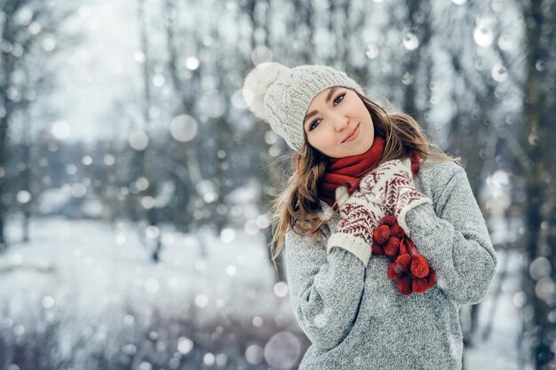 Zdjęcie portret młodej kobiety zimowej piękności radosna modelka śmiejąca się i bawiąca się w zimowym parku beautifu