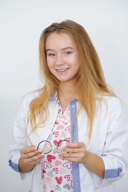 Portret młodej lekarki w białym fartuchu