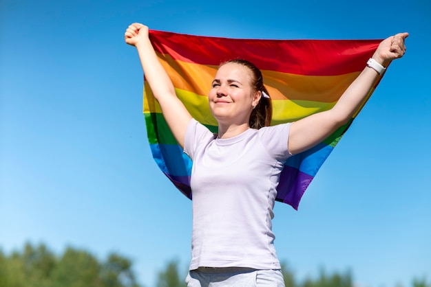 Portret młodej lesbijskiej szczęśliwej dumnej kobiety piękna dziewczyna macha tęczową flagą gejów w kolorze lgbt in