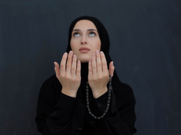 Portret młodej muzułmańskiej kobiety robi dua. Arabska dziewczyna ubrana w abaya trzyma ręce w geście modlitwy. Reprezentowanie kultu Boga i koncepcji Ramadan Kareem