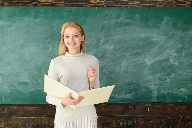 Zdjęcie portret młodej nauczycielki w klasie młodego, usatysfakcjonowanego profesora prof z folderowym portretem kobiety