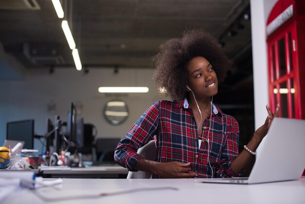 portret młodej, odnoszącej sukcesy Afroamerykanki, pięknej kobiety, która lubi spędzać radosne chwile podczas pracy w dużym nowoczesnym biurze