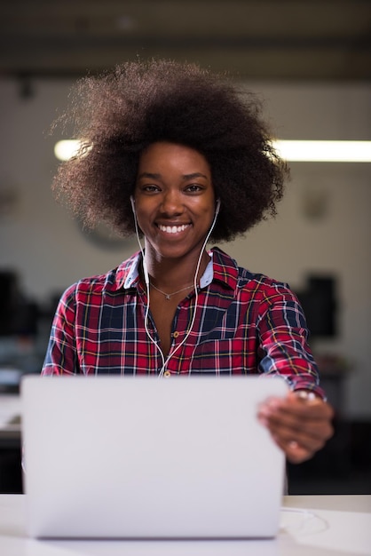 portret młodej, odnoszącej sukcesy Afroamerykanki, pięknej kobiety, która lubi spędzać radosne chwile podczas pracy w dużym nowoczesnym biurze