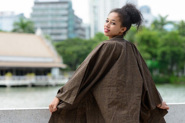 Portret młodej pięknej afrykańskiej kobiety z Afro włosów relaks w parku na świeżym powietrzu