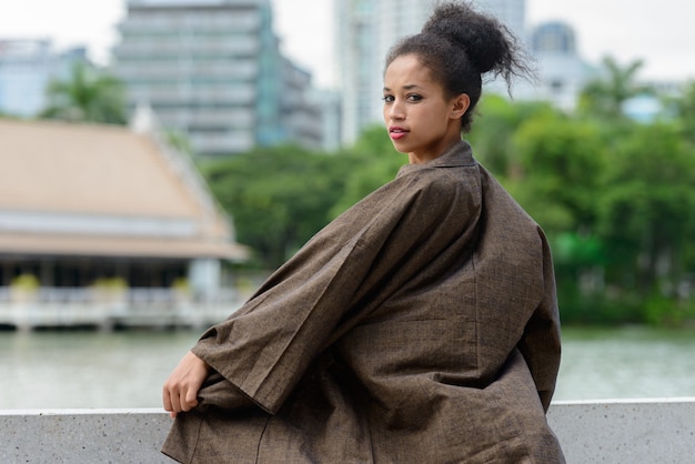 Portret młodej pięknej afrykańskiej kobiety z Afro włosów relaks w parku na świeżym powietrzu