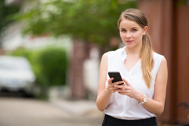 Portret młodej pięknej blond bizneswoman na ulicy na zewnątrz