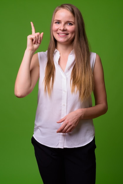 Portret młodej pięknej blond bizneswoman na zielono