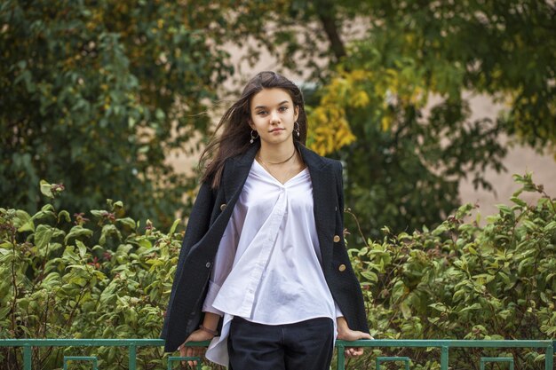 Portret młodej pięknej brunetki w letnim parku