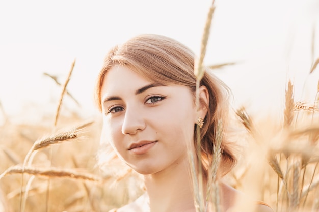 Portret młodej pięknej dziewczyny na polu pszenicy