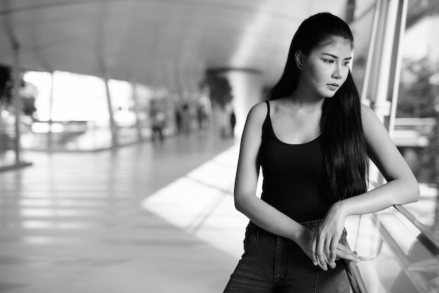 Portret młodej pięknej kobiety Azji zwiedzanie miasta w czerni i bieli