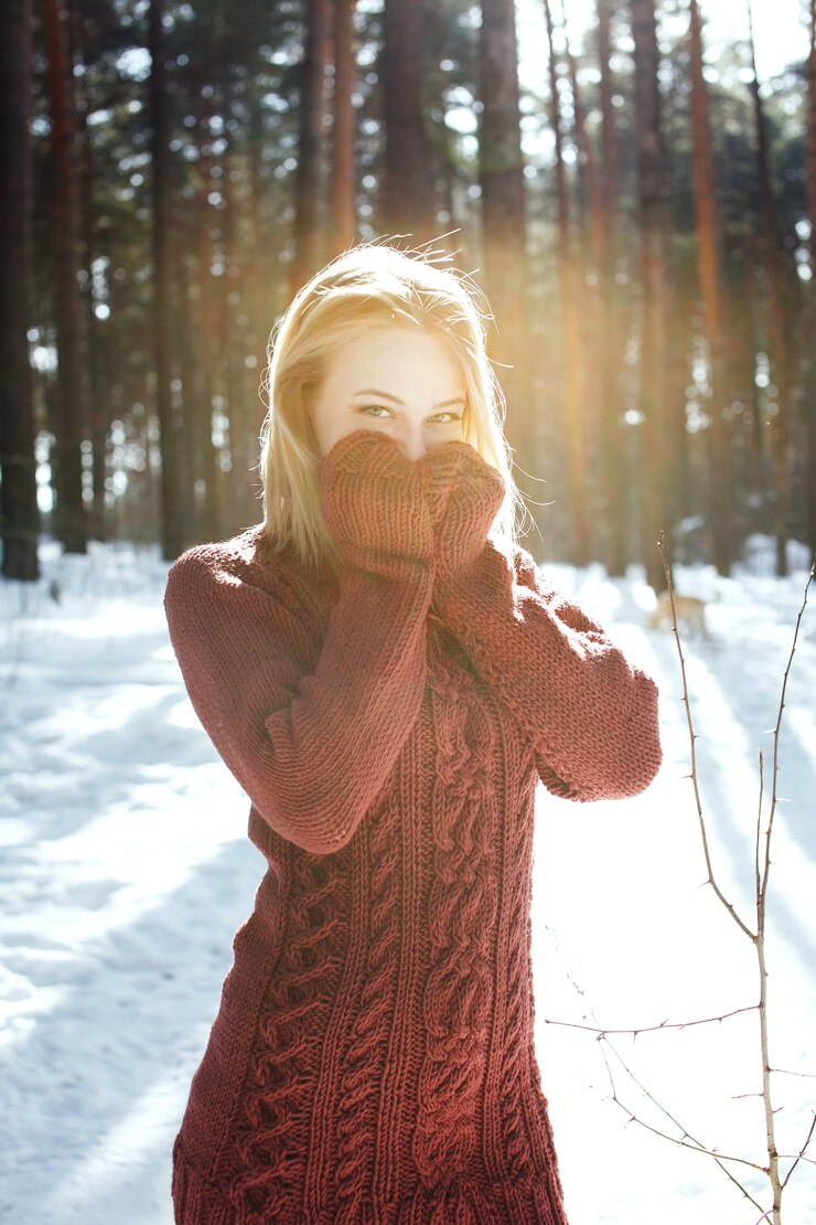 Zdjęcie portret młodej pięknej kobiety blondynka w swetrze pozowanie w winter park. słoneczny dzień w lesie.
