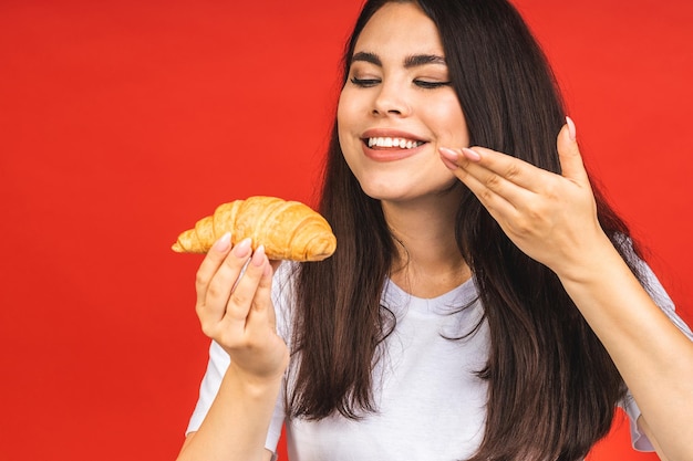 Portret Młodej Pięknej Kobiety Głodnej Jedzenia Rogalika Odosobniony Portret Kobiety Z Fast Foodem Na Czerwonym Tle Koncepcja śniadania Dietetycznego