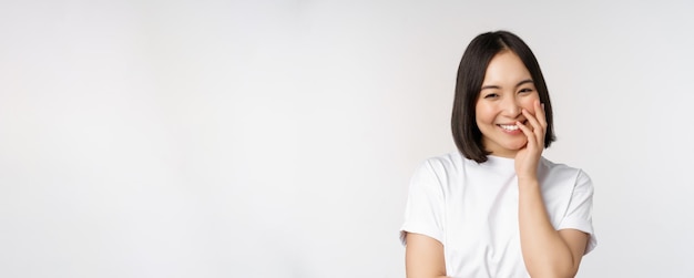 Portret młodej pięknej kobiety koreańskiej dziewczyny śmiejącej się i uśmiechającej się zalotnie stojącej ponownie