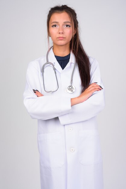 Portret młodej pięknej kobiety lekarz przed białą ścianą