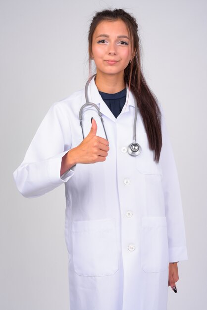 Portret młodej pięknej kobiety lekarz przed białą ścianą