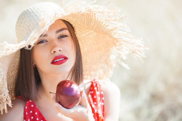 Portret młodej pięknej kobiety na zewnątrz w soczyste lato lub jesień Kobieta w czasie upadku. Pani o charakterze ubrana w czerwoną stylową sukienkę.