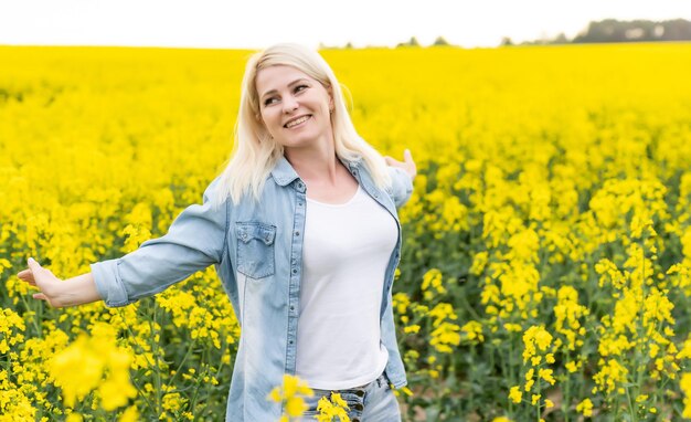 Portret młodej pięknej kobiety w kwitnącej łące rzepaku.