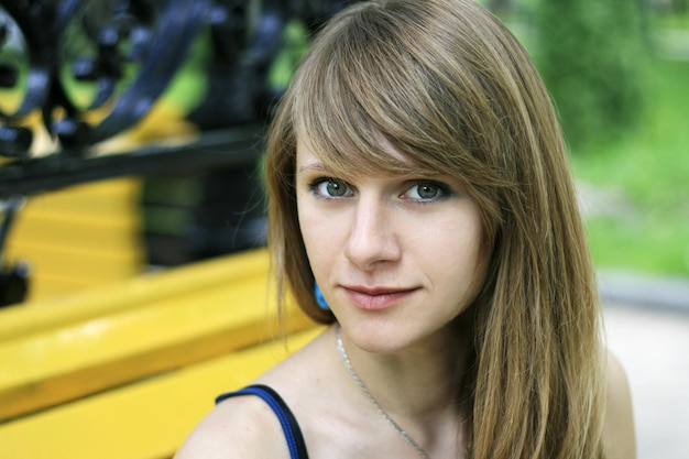 Zdjęcie portret młodej pięknej ukrainki o blond włosach i niebieskich oczach siedzącej na ulicy