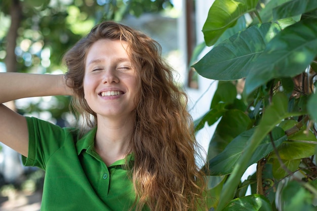 Portret młodej pozytywnej dziewczyny w pobliżu jej domu eko koncepcja wiejskiego życia wiosna lato ogród zielony