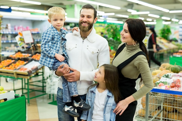 Portret młodej rodziny z synem i córką w supermarkecie.