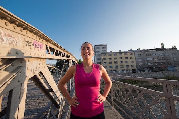 portret młodej sportowej kobiety biegającej w słoneczny poranek w mieście