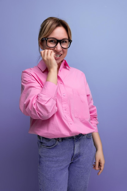 Portret młodej, udanej, blond, karierowej liderki w różowej bluzce i okularach