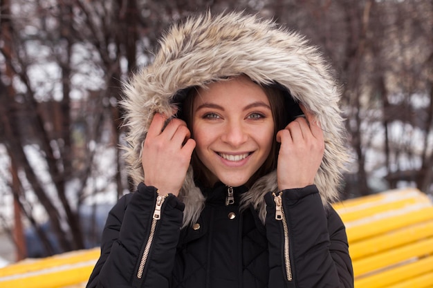 Portret młodej uroczej kobiety w zimie stojącej na zewnątrz