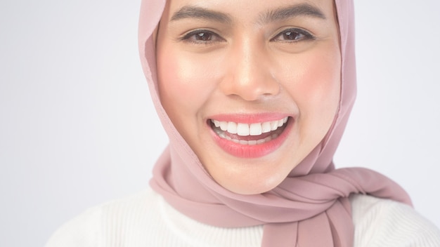 Portret Młodej Uśmiechniętej Muzułmańskiej Kobiety Ubrana W Różowy Hidżab Na Białym Tle.