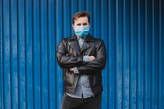 Portret młody człowiek jest ubranym medyczną maskę. koncepcja koronawirusa. ochrona dróg oddechowych