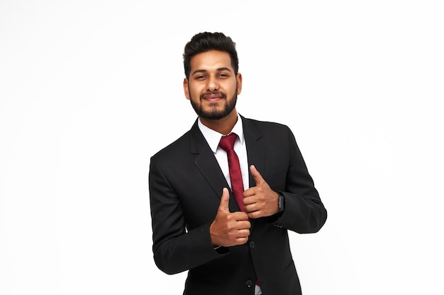 Zdjęcie portret młody szczęśliwy indyjski biznesowy mężczyzna na białym odosobnionym tle patrzeje kamerę.