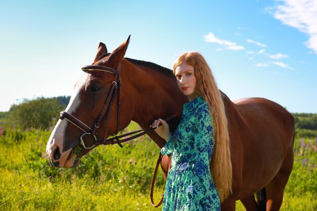 Portret młody uśmiechnięty piękny kobiety odprowadzenie z brown koniem outdoors