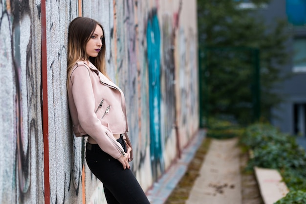 Portret modna dziewczyna na graffiti ścianie