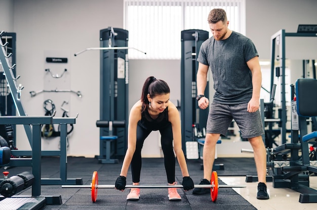 Portret muskularnych młodych ludzi z pięknymi wysportowanymi ciałami na siłowni Koncepcja kulturystyki fitness i opieki zdrowotnej