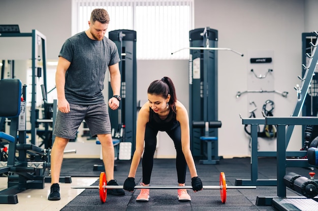 Portret muskularnych młodych ludzi z pięknymi wysportowanymi ciałami na siłowni Koncepcja kulturystyki fitness i opieki zdrowotnej