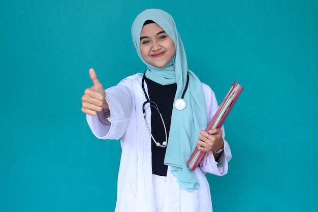 Portret muzułmańskiej lekarki ze stetoskopem w białym płaszczu trzymającej dokument medyczny podczas g