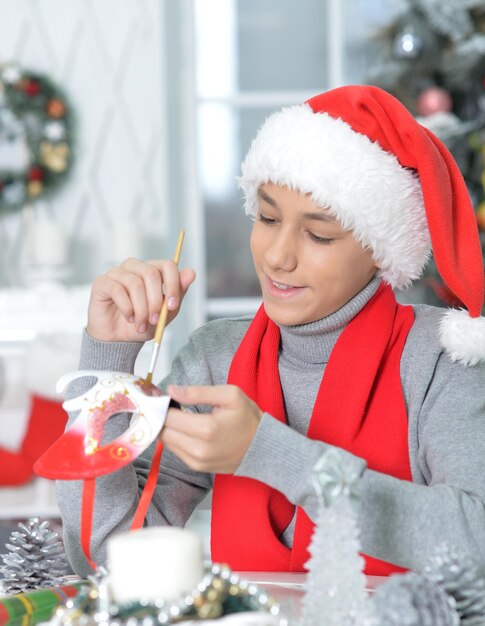 Portret nastoletniego chłopca przygotowującego się do Bożego Narodzenia w domu