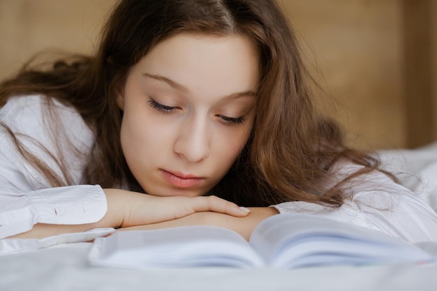 Portret Nastoletniej Dziewczyny Czytającej Książkę Leżącą Na łóżku