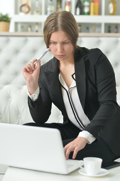 Portret nastoletniej dziewczyny w formalnej odzieży przy użyciu laptopa