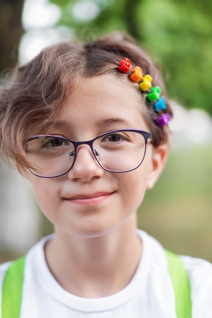 Zdjęcie portret nastoletniej dziewczyny z kolorowymi tęczowymi spinkami do włosów, motyw lgbtq, duma
