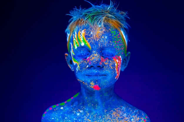 Portret neonowego dziecka chłopiec pozuje w UV