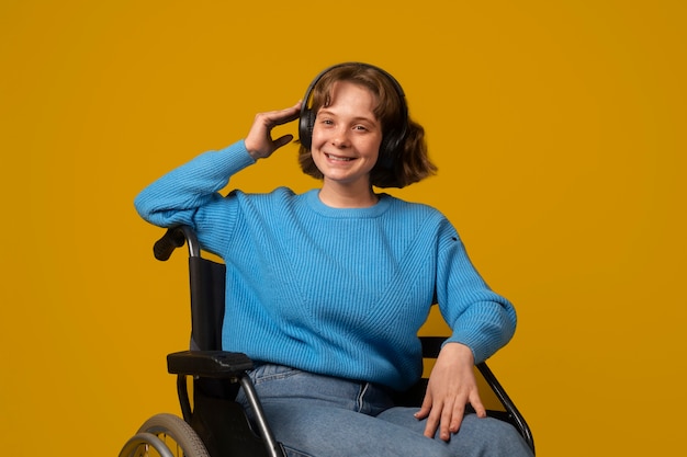 Zdjęcie portret niepełnosprawnej kobiety na wózku inwalidzkim ze słuchawkami