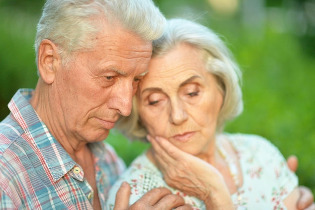 Zdjęcie portret nieszczęśliwej pary seniorów pozującej w letnim parku