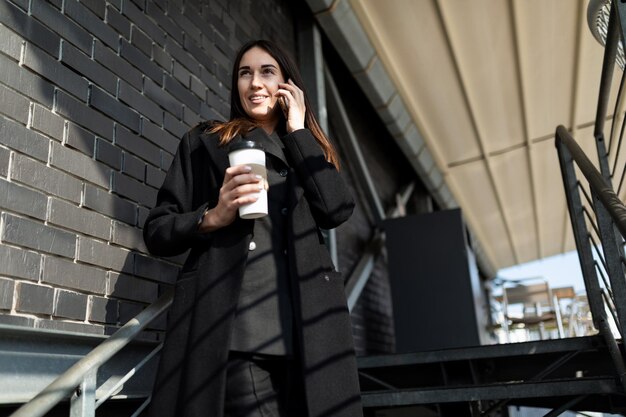 Portret odnoszącej sukcesy nowoczesnej niezależnej kobiety w biznesowych ubraniach rozmawiającej przez telefon komórkowy na A