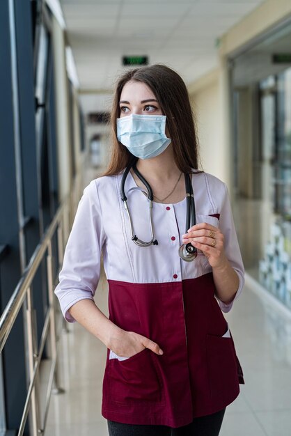 Portret odnoszącej sukcesy uśmiechniętej pielęgniarki w masce chroniącej przed covidem