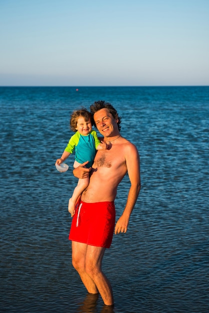 Portret ojca i córki stojących na plaży na tle nieba